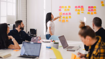 Équipe réunie devant un mur de post-it colorés pendant un atelier de cadrage