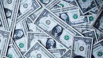 Billets de un dollar américain éparpillés en tas