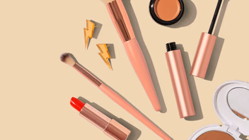 Pinceaux, rouge à lèvres, poudre et fard à paupières disposés à plat sur un fond beige